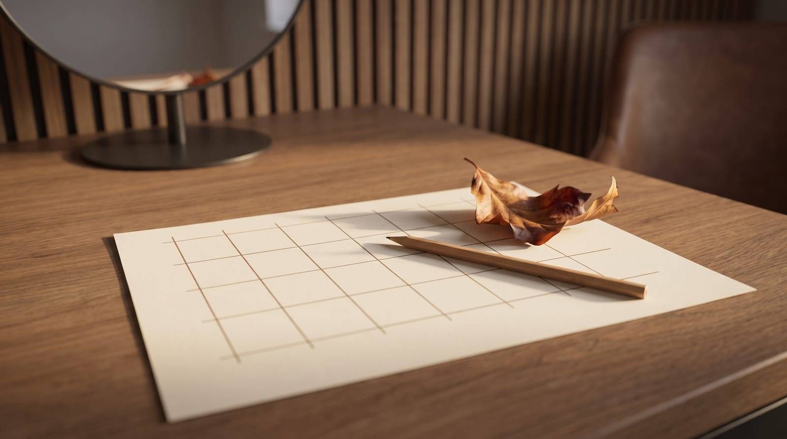 A blank weekly tracking grid on paper with a pencil and a dried autumn leaf on the desk at Kennedy SMP Studio in Haverhill