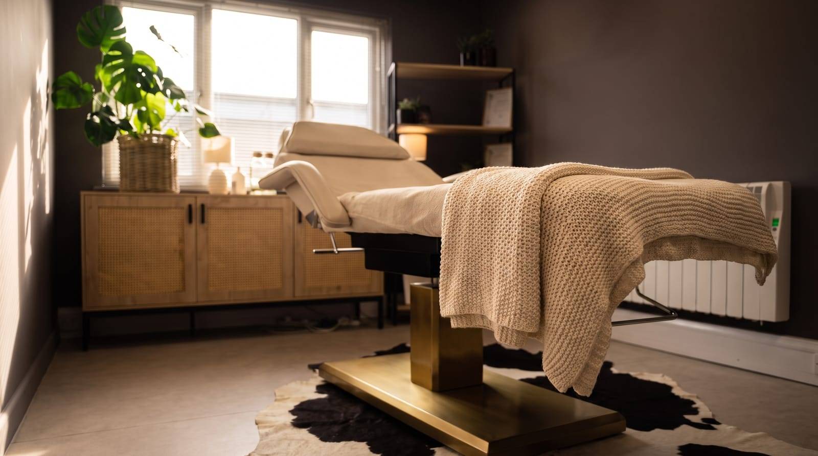 A soft knit throw folded over the arm of the empty treatment chair at Kennedy SMP Studio in Haverhill, a calm place for an honest conversation about hair thinning
